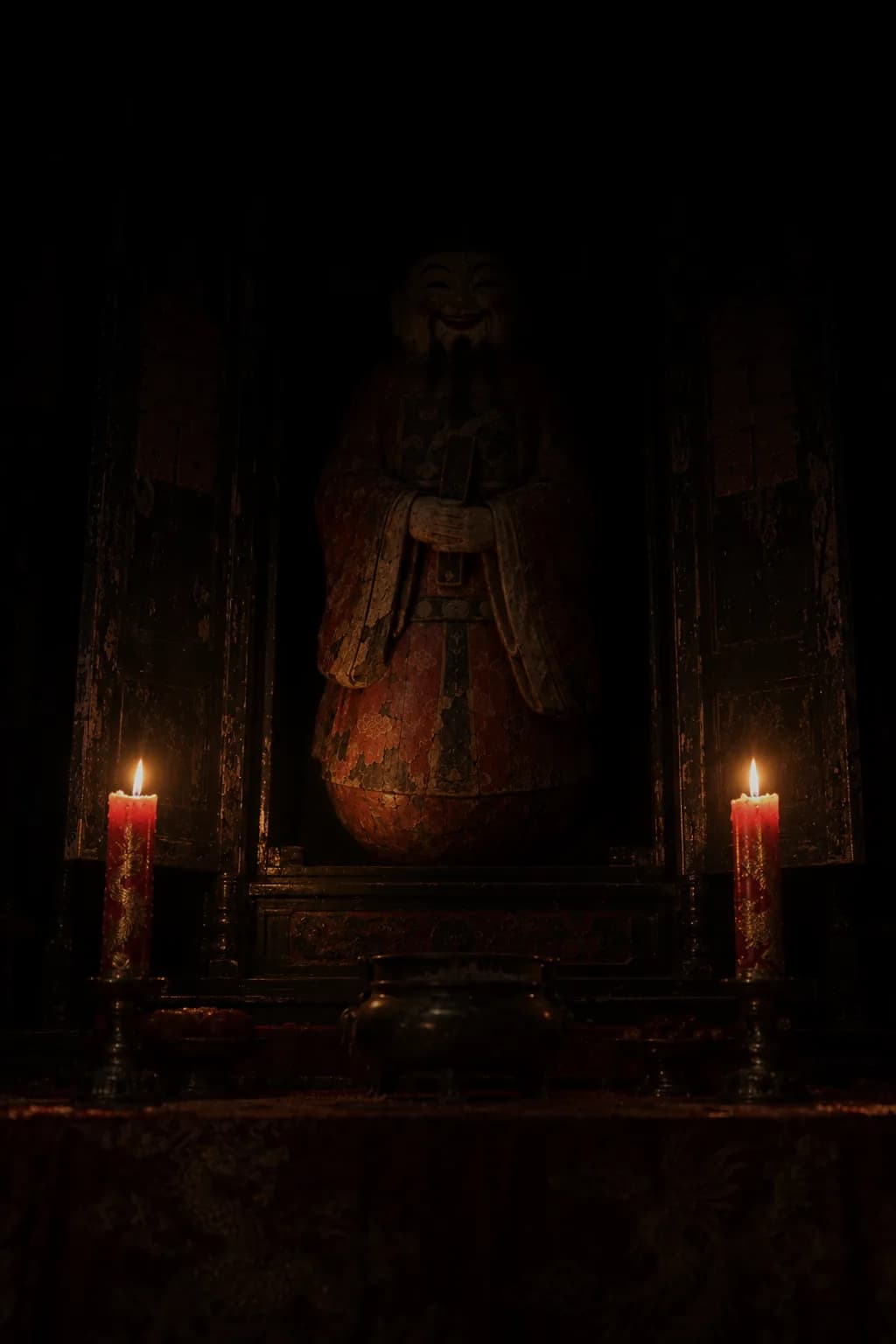 Wooden figure and candlelight in the ancestral hall